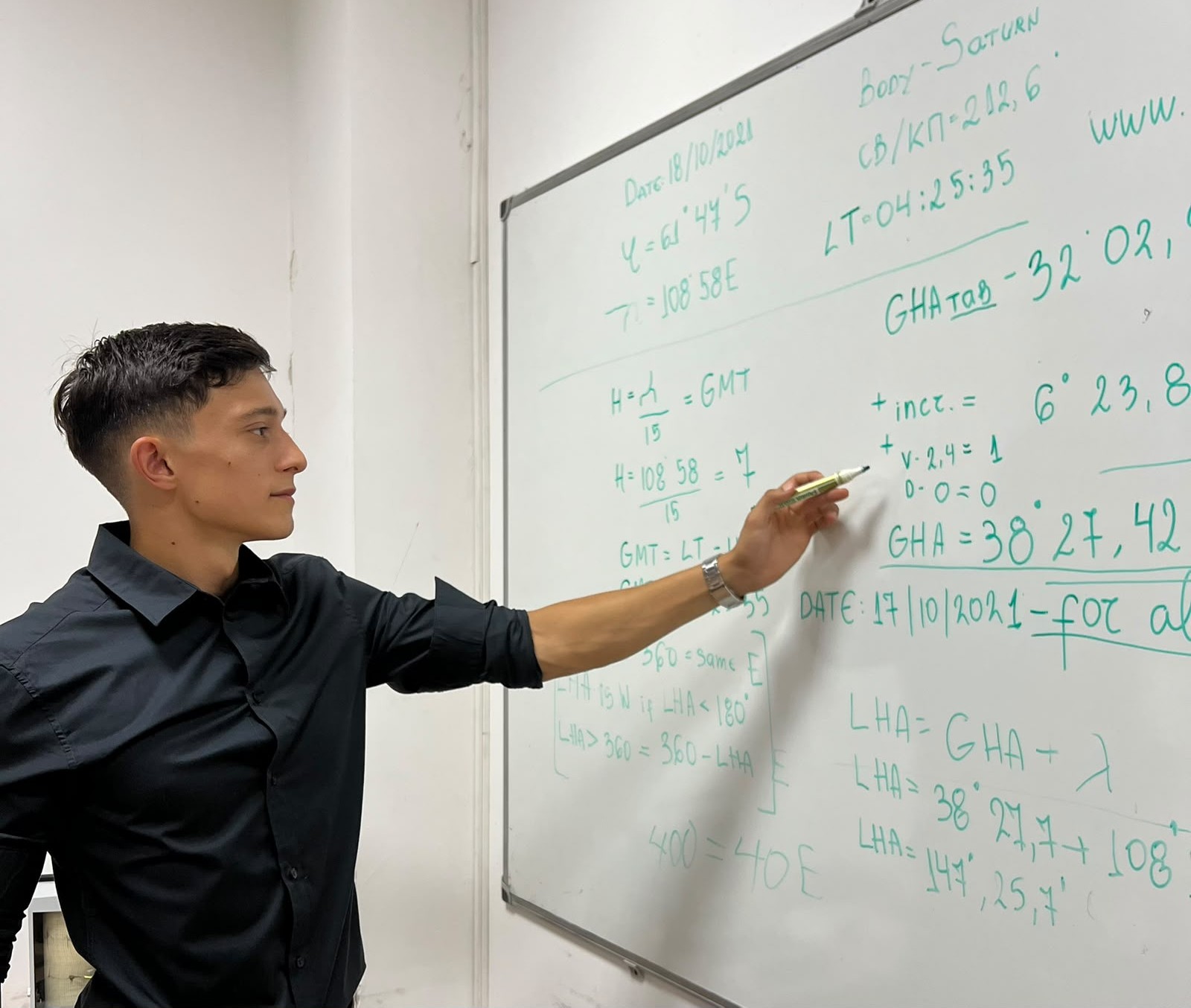 A cadet working through celestial-navigation calculations on a whiteboard
